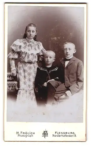 Fotografie M. Frölich, Flensburg, Norderhofenden 9, Mädchen in elegantem Kleid und zwei Jungen in Anzügen