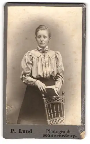 Fotografie P. Lund, Süderbrarup, Junge Frau in eleganter Bluse mit einem Buch in der Hand