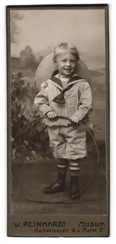 Fotografie W. Reinhardt, Husum, Catharinenstrasse 10, Lächelnder kleiner Junge im gestreiften Matrosenanzug