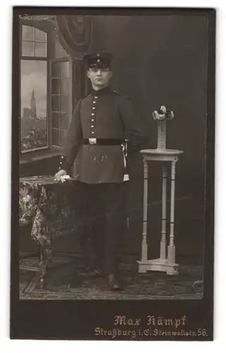 Fotografie Max Kämpf, Strassburg i. E., Steinwallstr. 56, Soldat in Uniform mit Bajonett vor einer Studiokulisse