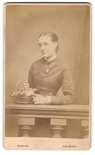 Fotografie Parker, Holborn, 40. High Holborn, Dame mit Medaillon und Blumenkörbchen