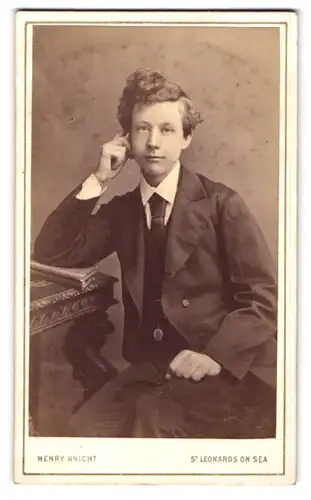 Fotografie Henry Knight, St. Leonards on Sea, Junger Mann mit abstützender Hand am Tisch