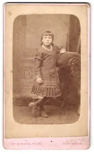 Fotografie W. Seward, Nottingham, Market Street, Kind im Kleid an Recamiere anlehnend