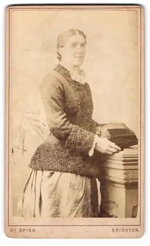 Fotografie H. Spink, Brighton, Western Road 109, Frau mit Mittelscheitel in Kleid mit Persianerbesatz