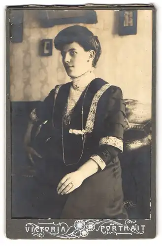 Fotografie Victoria Portrait, Ort unbekannt, Junge Frau in spitzenbesetzem Kleid in einem Wohnzimmer