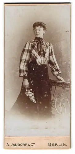 Fotografie A. Jandorf & Co, Berlin, Dame in karierter Bluse mit Blütenbouquet