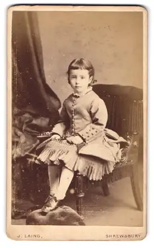 Fotografie J. Laing, Shrewsbury, Castle Street, Mädchen im plissierten Kleid auf Stuhl sitzend