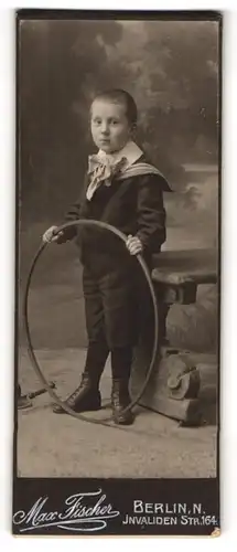 Fotografie Max Fischer, Berlin N., Invalidenstr. 164, Kind im Anzug mit einem Reifen
