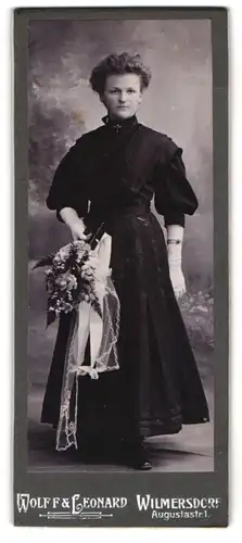 Fotografie Wolff & Leonard, Wilmersdorf, Augustastrasse 1, Konfirmandin in festlichem Kleid mit Blumenstrauss in der Hand