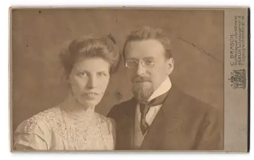 Fotografie C. Brasch, Berlin, Leipzigerstrasse 8, Junge Frau in Spitzenbluse und eleganter Mann mit Spitzbart und Brille