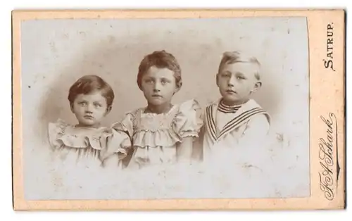 Fotografie F. A. Schark, Satrup, Zwei Kinder in Rüschenkleidchen und ein Knabe im Matrosenanzug
