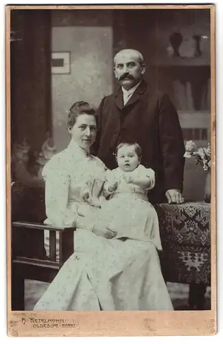 Fotografie H. Ketelhohn, Bad Oldesloe, Bürgerliches Paar mit einem Kleinkind