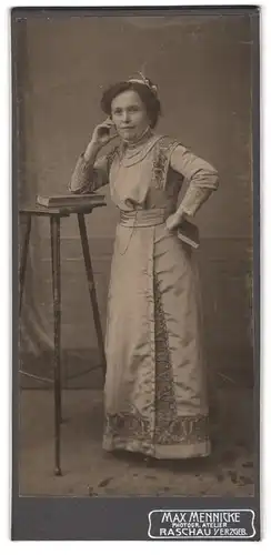 Fotografie Max Mennicke, Raschau /Erzgeb., Dame im Bordürenkleid an einem Stehtischchen