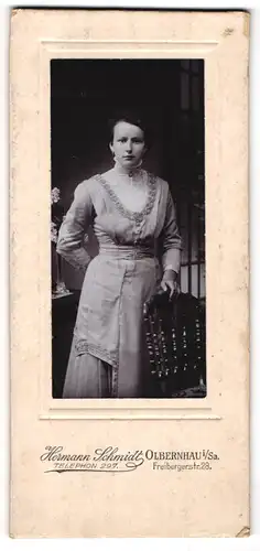 Fotografie Hermann Schmidt, Olbernhau, Freibergerstrasse 28, Junge Frau in verziertem Kleid mit hohem Spitzenkragen