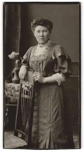 Fotografie unbekannter Fotograf und Ort, Junge Frau mit ondulierten Harren im spitzenverziertem Sonntagskleid