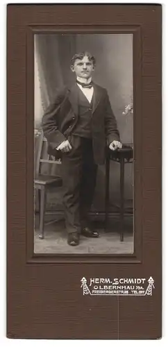 Fotografie Herm. Schmidt, Olbernhau, Freibergerstrasse 28, Junger Mann mit Stirnlocken und gedrungener Figur im Anzug