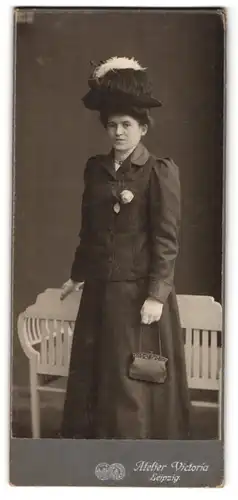 Fotografie Knoth & Heine, Leipzig, Rossplatz 6, Junge Frau mit hohem Federhut, Handtäschchen und ernstem Blick