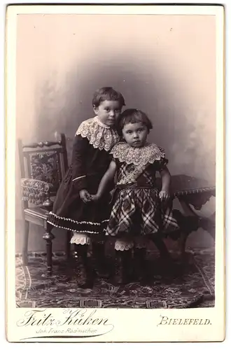 Fotografie Fritz Küken, Bielefeld, zwei kleine Kindern in Kleidern mit Spitzenkragen und Topfhaarschnitt