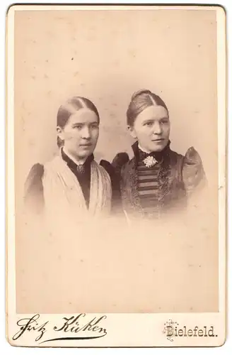 Fotografie Fritz Küken, Bielefeld, zwei junge Frauen in Biedermeierkleidern mit Brosche