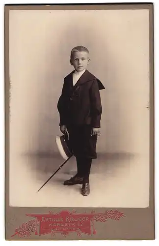 Fotografie Arthur Krüger, Berlin, Karlstr. 23, junger Knabe im Anzug mit halblanger Hose samt Stock und Hut