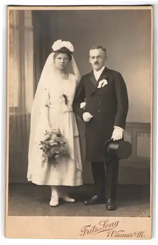 Fotografie Fritz Seng, Wismar i. M., elegantes Hochzeitspaar nach der Trauung, Herr mit Zylinder & Braut mit Strauss