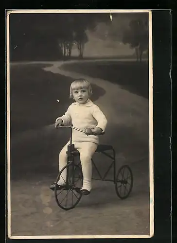 Foto-AK Kleiner Junge auf seinem Dreirad im Park am Abend