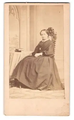 Fotografie Robert Hummel, Cöthen, junge Frau im dunklen Biedermeierkleid mit geflochtenen zurückgebundenen Haaren