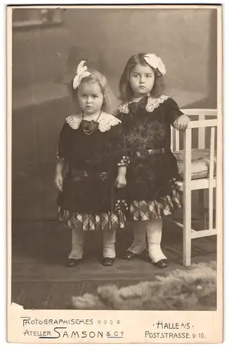 Fotografie Samson & Co., Halle, Poststrasse 9-10, Zwei kleine identisch gekleidete Mädchen mit Haarschleifen