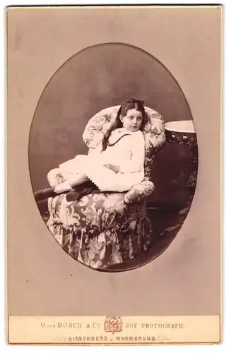 Fotografie O. von Bosch & Co., Hirschberg, Kleines Mädchen im weissen Kleid auf einem Sessel