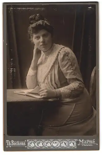 Fotografie Th. H. Backens, Marne, Bürgerliche Dame mit einem Buch am Tisch