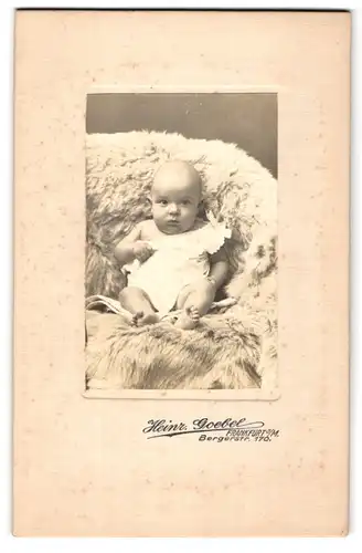 Fotografie Heinr. Goebel, Frankfurt a. M., Bergerstr. 170, Süsses Kleinkind im Hemd sitzt auf Fell