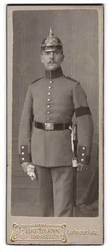 Fotografie J. Hartmann, Bayreuth, junger Soldat in Uniform mit Pickelhaube und Säbel, Trauerflor Armbinde