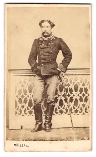 Fotografie Müller L., Debreczenben, Portrait russischer Soldat in Uniform mit Fell und Säbel, Moustache