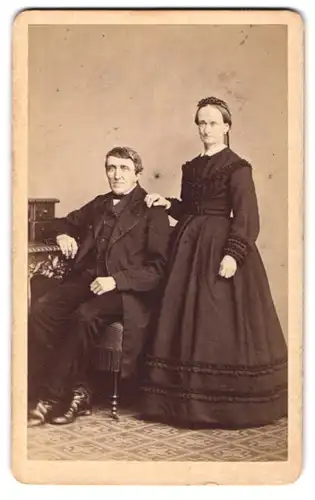 Fotografie B. Sparmeyer, Herrnhut, Berthelsdorferstr. 14, älteres Paar im Biedermeierkleid und im Anzug