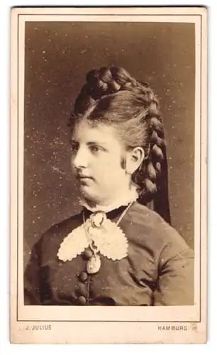 Fotografie J. Julius, Hamburg, junge Dame im hochgeschlossenen Kleid mit geflochtenen Haaren, Halskette