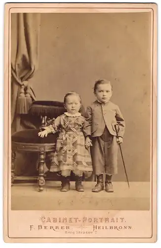 Fotografie Cabinet-Portrait F. Berrer, Heilbronn, Berg-Strasse 2, Zwei Kinder im Kleid und Jacket halten Händchen