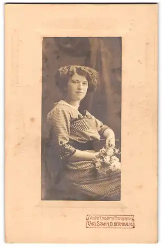 Fotografie Carl Spahn, Olbernhau i. S., Dame im gemusterten Kleid mit Blumenbouquet