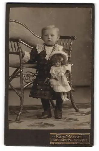 Fotografie Karl Mäckel, Burgstädt i. Sa., Böhmestr. 2, kleines Mädchen im karierten Kleid mit grosser Puppe im Arm