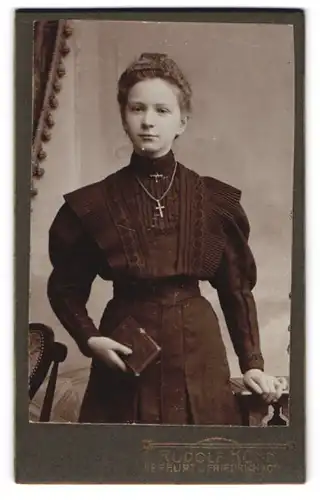 Fotografie Rudolf Kühn, Erfurt, Portrait Mädchen im schwarzen Kleid zu ihrer Kommunion mit Kruzifix