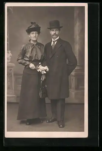 Foto-AK Ehepaar mit strengem Blick vor Studiokulisse