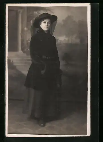 Foto-AK Dame in schwarzer Kleidung mit Muff vor Studiokulisse