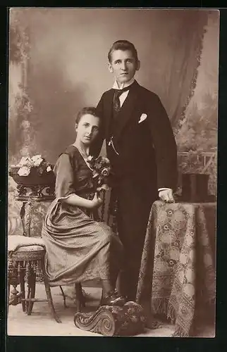 Foto-AK Ehepaar in feiner Kleidung, Studiokulisse
