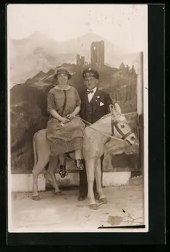 Foto-AK Chauffeur mit Dame auf Kunststoffesel vor Burgkulisse