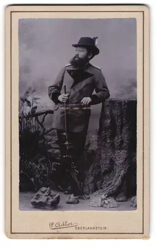 Fotografie P. Adler, Oberlahnstein, Portrait Förster in Dienstuniform mit Flinte posiert im Atelier