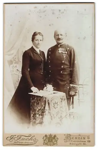 Fotografie J. Fuchs, Berlin, Portrait Eisenbahner in Uniform mit Ordenspange nebst seiner Frau