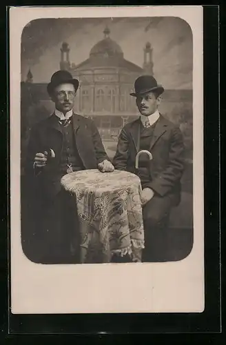 Foto-AK Zwei Herren mit Melonen an einem Tischchen vor einer Kulisse