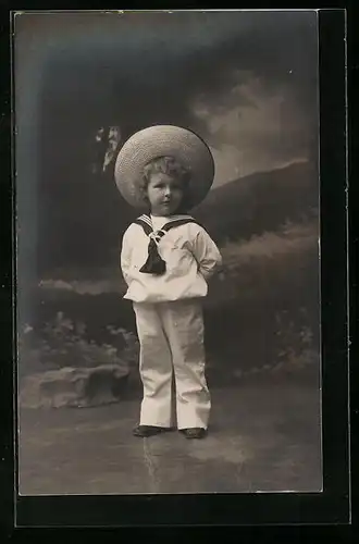 Foto-AK Kleiner Junge mit Strohhut im Matrosenanzug vor Landschaftskulisse