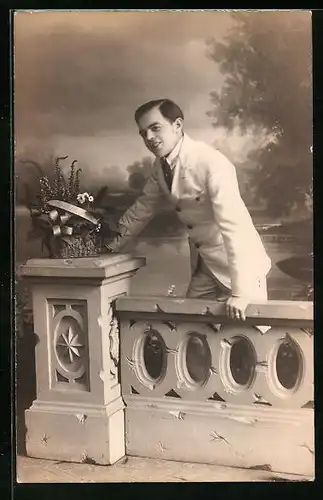 Foto-AK Junger Mann hinter Balustrade vor Landschaftskulisse