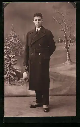 Foto-AK Junger Mann im Mantel vor winterlicher Landschaftskulisse