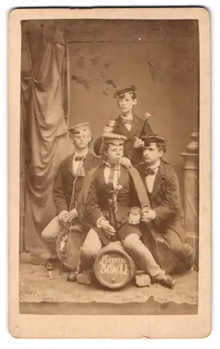 Fotografie unbekannter Fotograf und Ort, Portrait vier junge Studenten in Anzügen auf Bowl Fässern beim Umtrunk